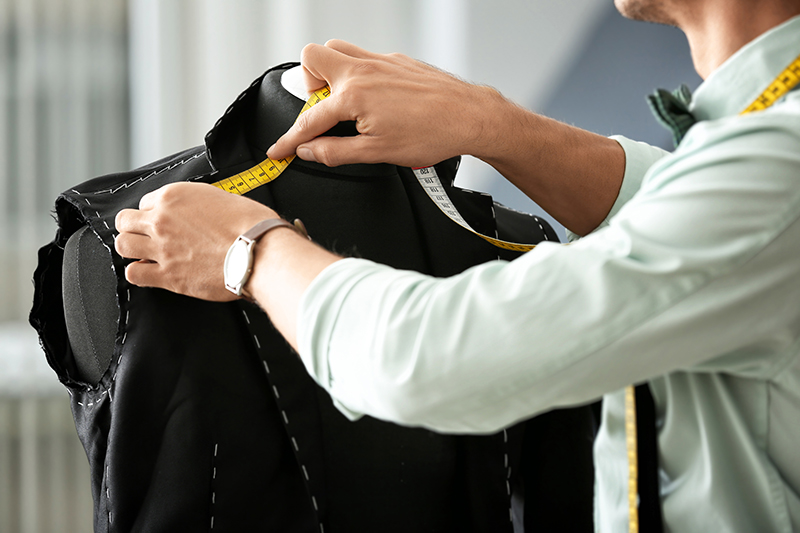 A tailor making a suit jacket in an atelier