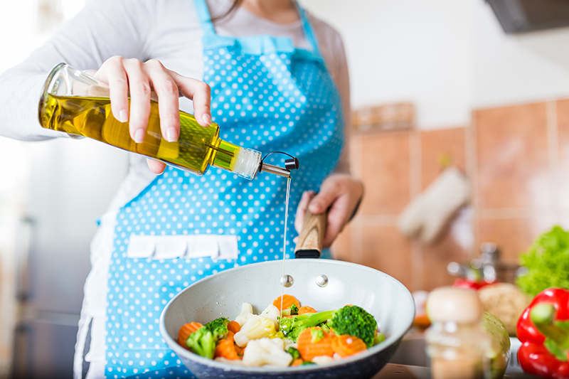 Pouring olive oil over vegetables - What is EVOO?